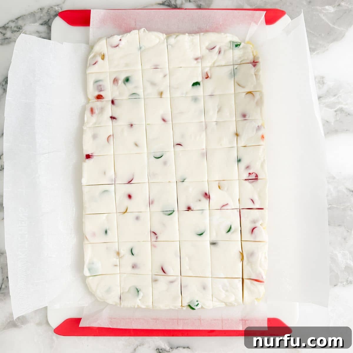 Gumdrop Nougat Cloud 7 Neatly sliced pieces of gumdrop nougat candy arranged on a wooden cutting board, showcasing their colorful appeal.