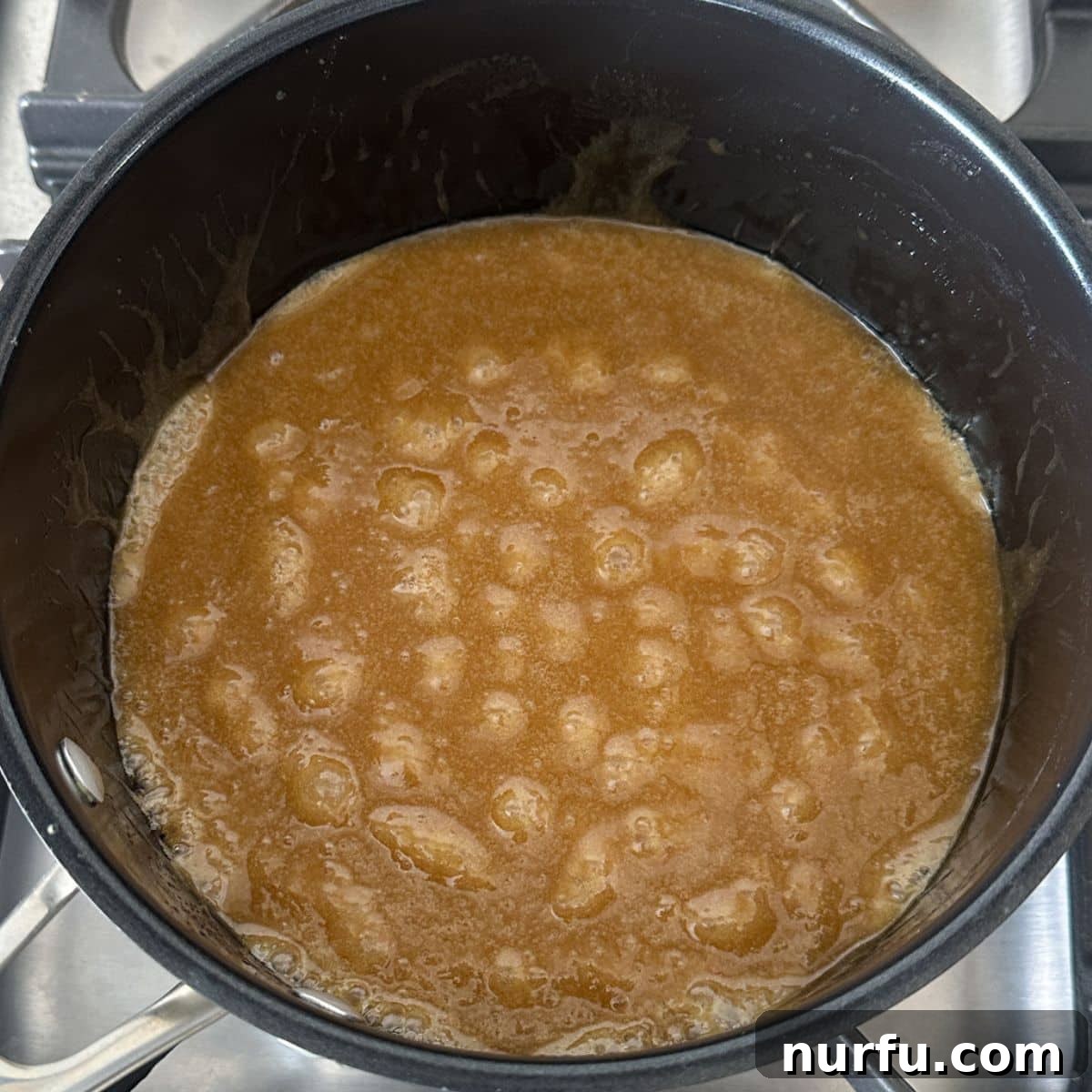Golden Caramel Clouds 4 A saucepan on the stove with a bubbling, golden caramel sauce being stirred.