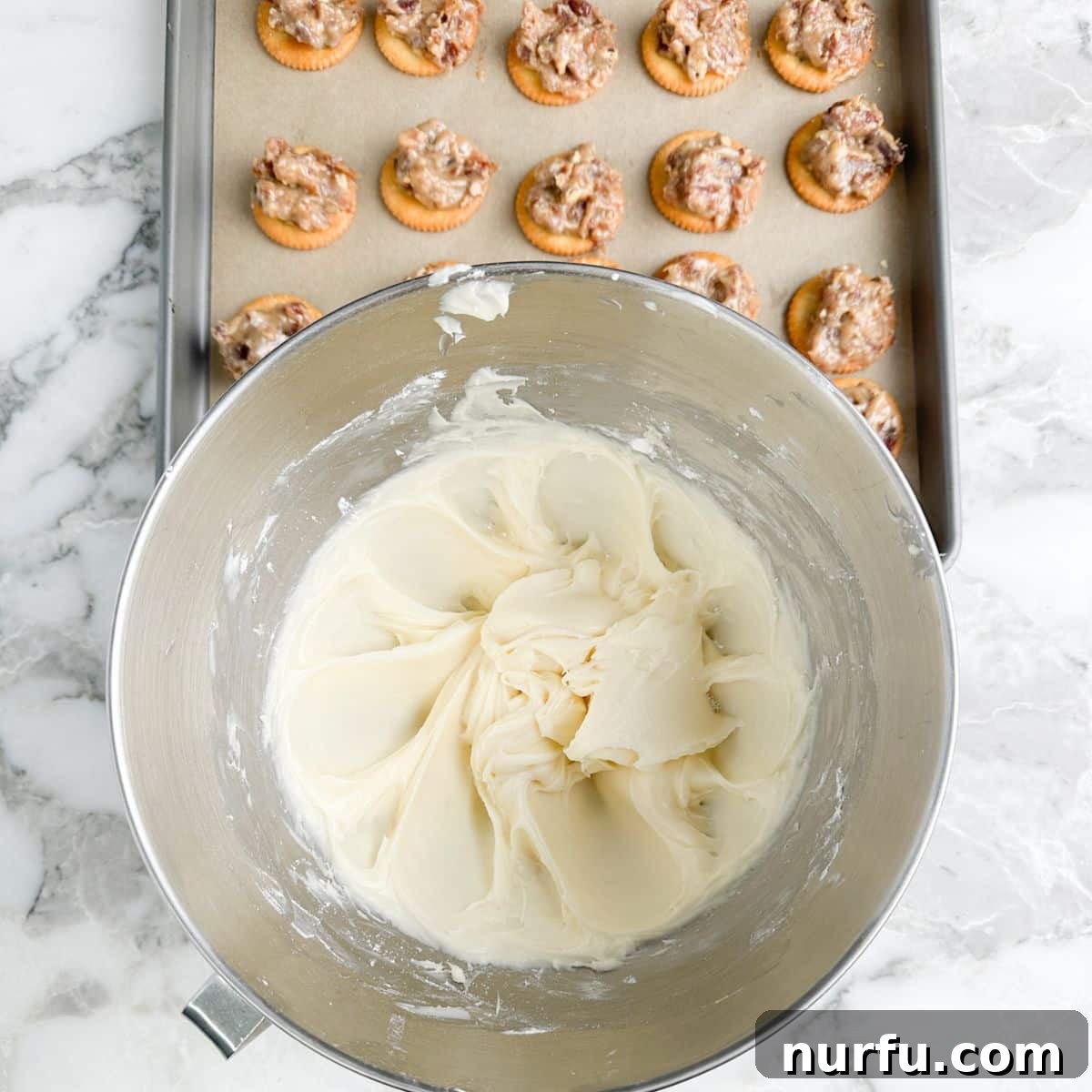 Sweet and Salty Ritz Cracker Delights 6 Bowl of freshly made cream cheese frosting next to a pan of Ritz cookies topped with pecan and date filling.