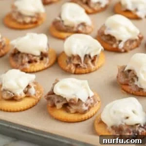 Pan with Ritz crackers topped with pecans and frosting.