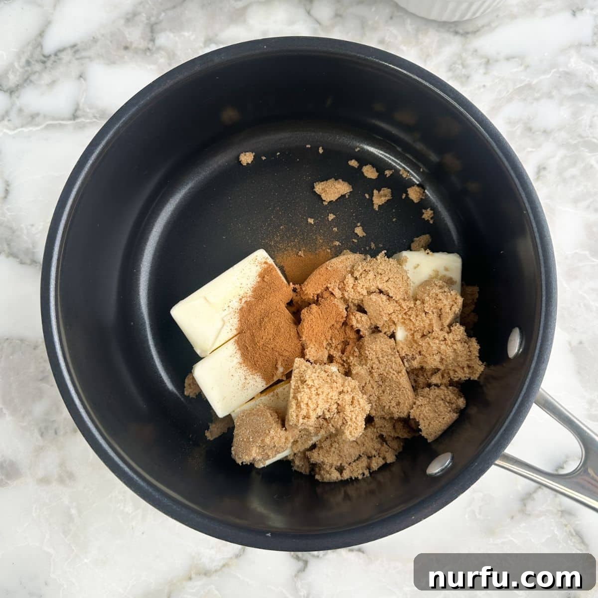 Saucepan with butter, brown sugar, and cinnamon. 