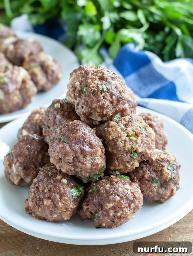 Delicious Basic Meatballs Stacked, perfectly baked meatballs on a white plate ready to be served