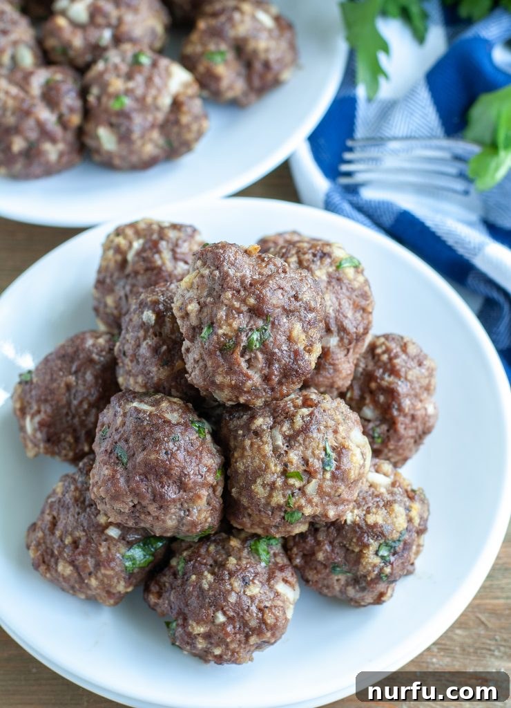 Versatile Basic Meatballs A small pile of baked meatballs on a clean white plate, ready for serving or saucing