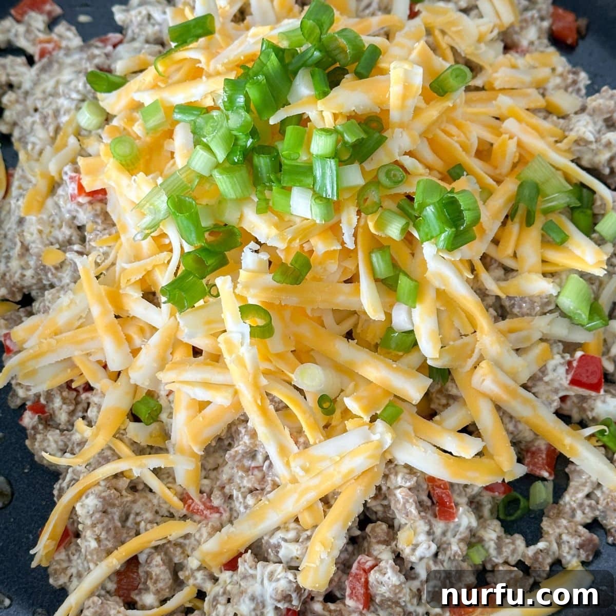 Sausage Cream Cheese Poppers 6 Skillet with ground sausage, shredded cheese, and green onions.