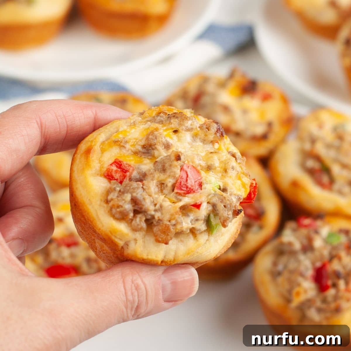 Sausage Cream Cheese Poppers 8 Hand holding a cream cheese sausage bites.