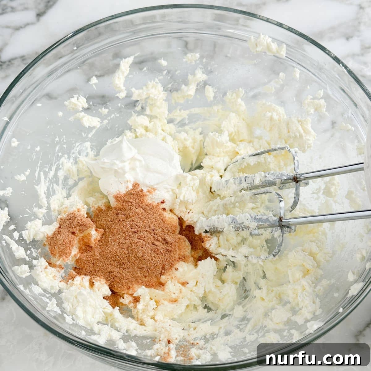 A mixing bowl filled with the creamy base of Fire Cracker Dip, a smooth blend of cream cheese, sour cream, mayonnaise, and seasonings.
