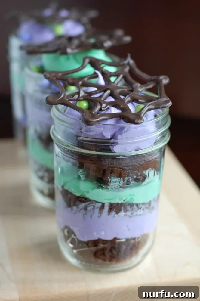 Halloween Mason Jar Cakes Halloween Mason Jar Cakes with chocolate spider web toppers, ready for a spooky party