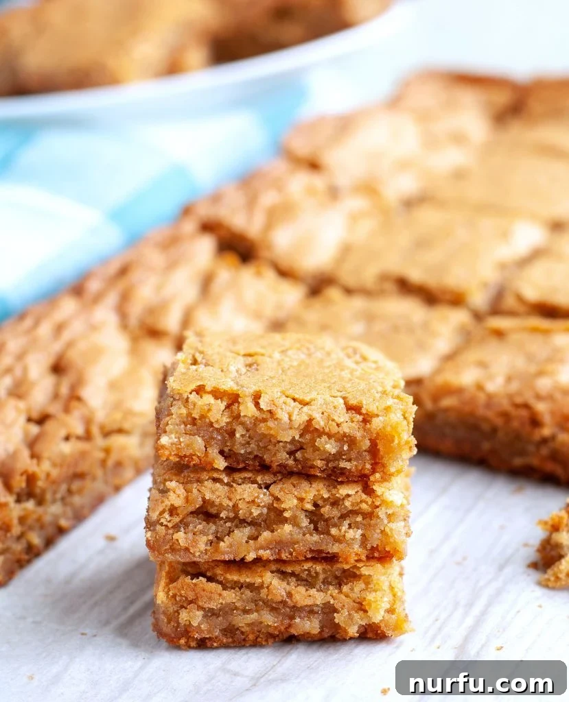 Chewy Butterscotch Brownies Three stacked butterscotch brownies, showcasing their golden-brown color and chewy texture.