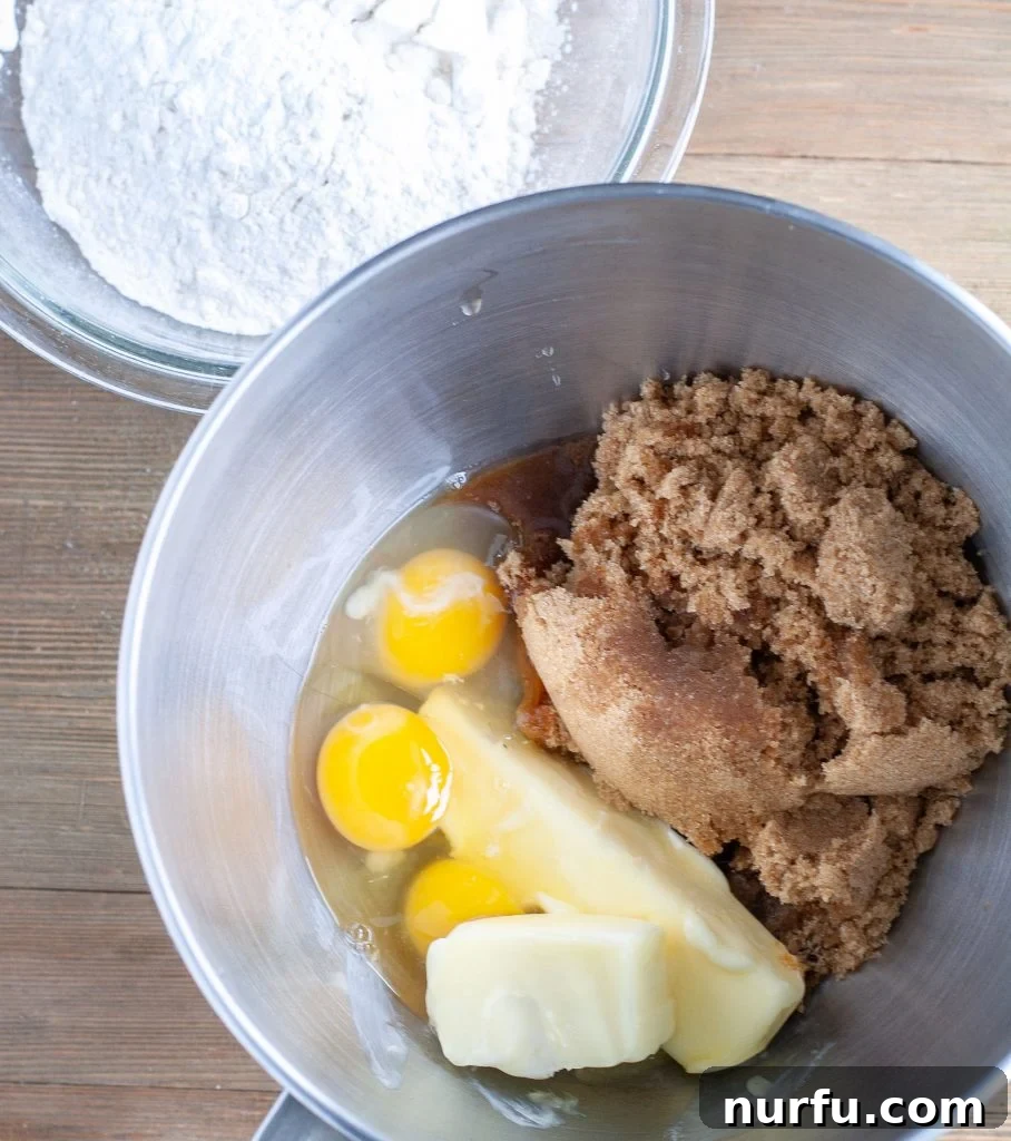 Butterscotch Brownie Batter Mixing bowl of brown sugar, eggs, butter and a separate bowl of flour mixture for butterscotch brownies.