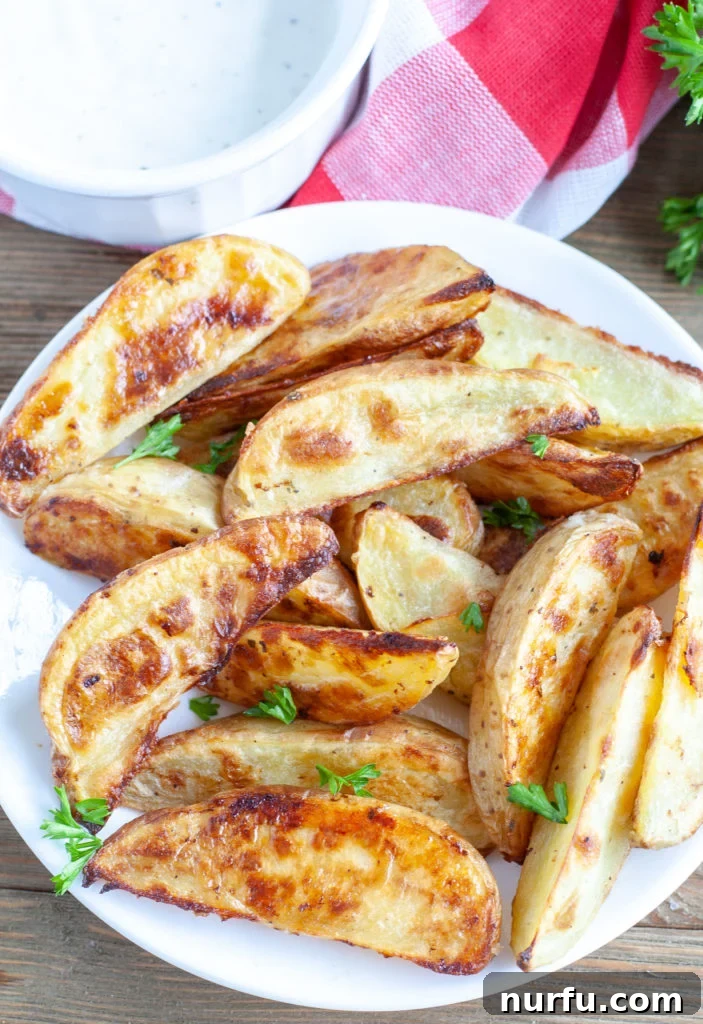 Zesty Ranch Potato Wedges 2 Potato wedges on a plate with ranch dipping sauce