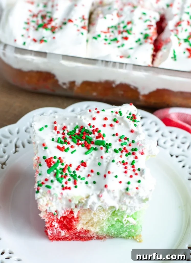 Delicious Holiday Jello Cake Vibrant Holiday Jello Cake slice on a festive plate, showcasing red and green Jello stripes.
