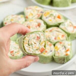 Hand holding vegetable pinwheels.