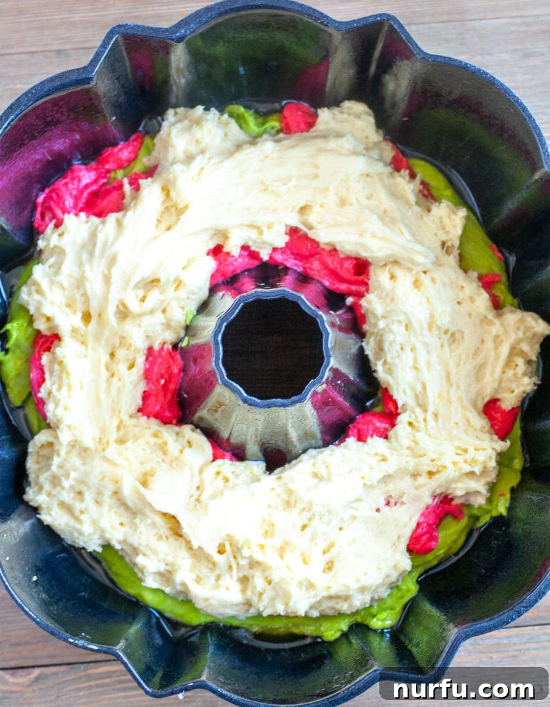 Holiday Bundt Pan Bundt cake batter with visible layers of red, green, and white in a bundt pan, ready for baking