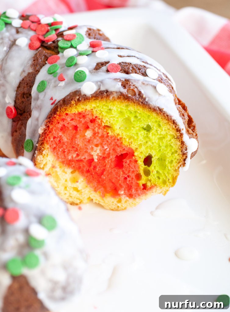 Holiday Bundt Cake A slice of Holiday Bundt Cake on a white plate, revealing its red, green, and white layers