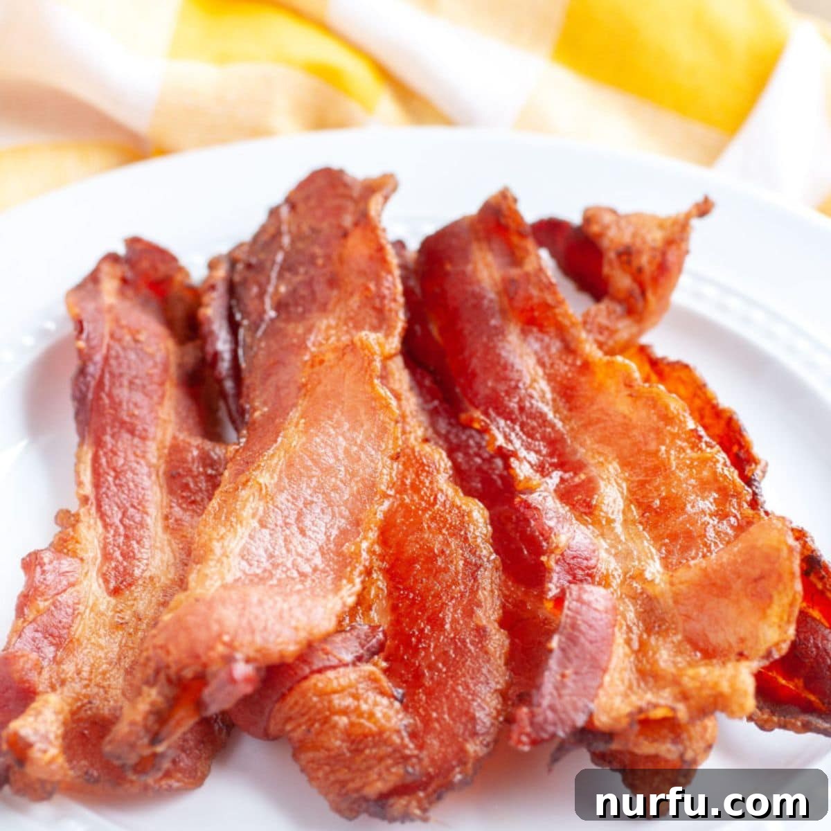 Crispy Air Fryer Bacon 4 A generously filled plate of golden, crispy air fryer bacon, perfectly cooked and ready to serve.