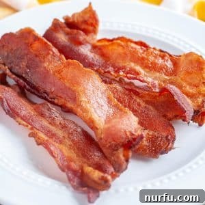 A plate with perfectly cooked, crispy air fryer bacon slices.