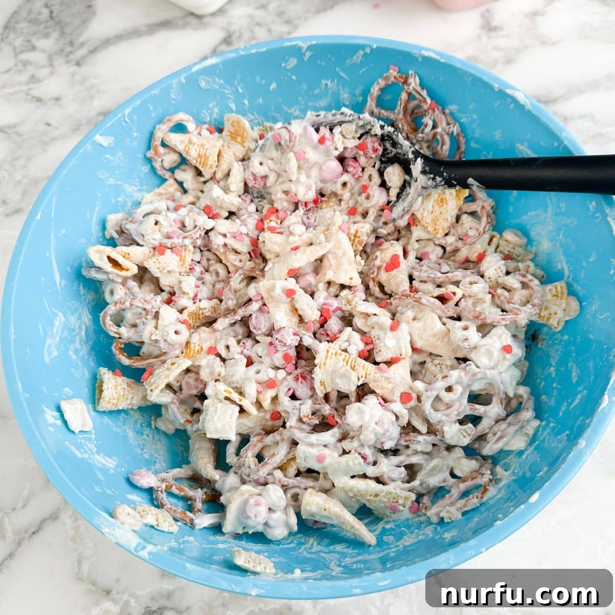 Blue bowl with Valentine's day snack mix.