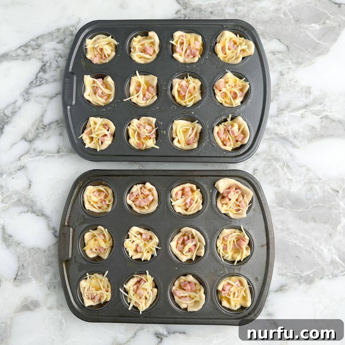 Savory Ham Puffs 7 A mini muffin tin with crescent dough cups neatly filled with the ham and cheese mixture, ready for baking.
