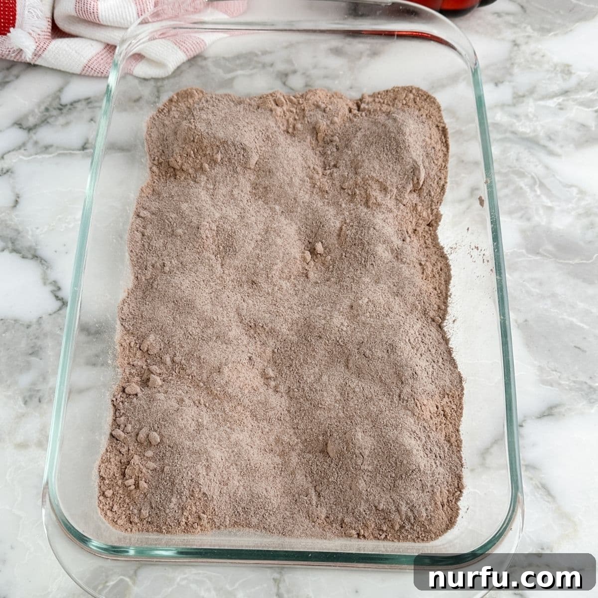 Effortless Chocolate Delight 4 Baking dish containing dry chocolate cake mix and pudding mix.