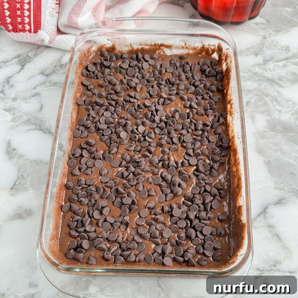 Effortless Chocolate Delight 7 Chocolate cake batter in baking dish topped with chocolate chips.