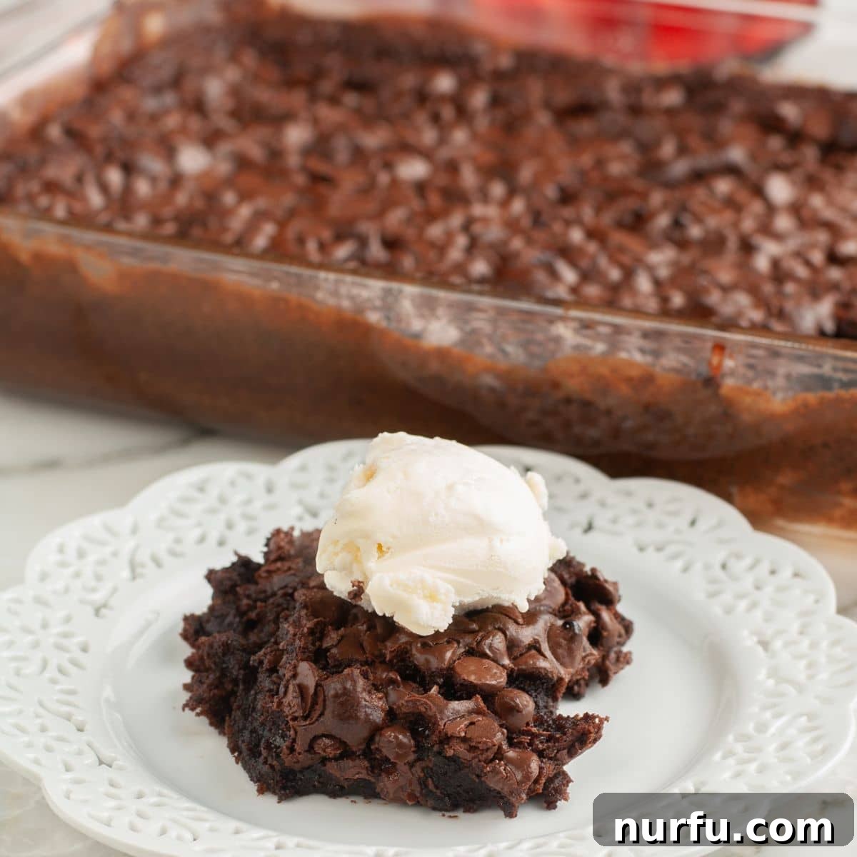 Effortless Chocolate Delight 8 Plate with a warm piece of chocolate dump cake topped with a scoop of melting vanilla ice cream.