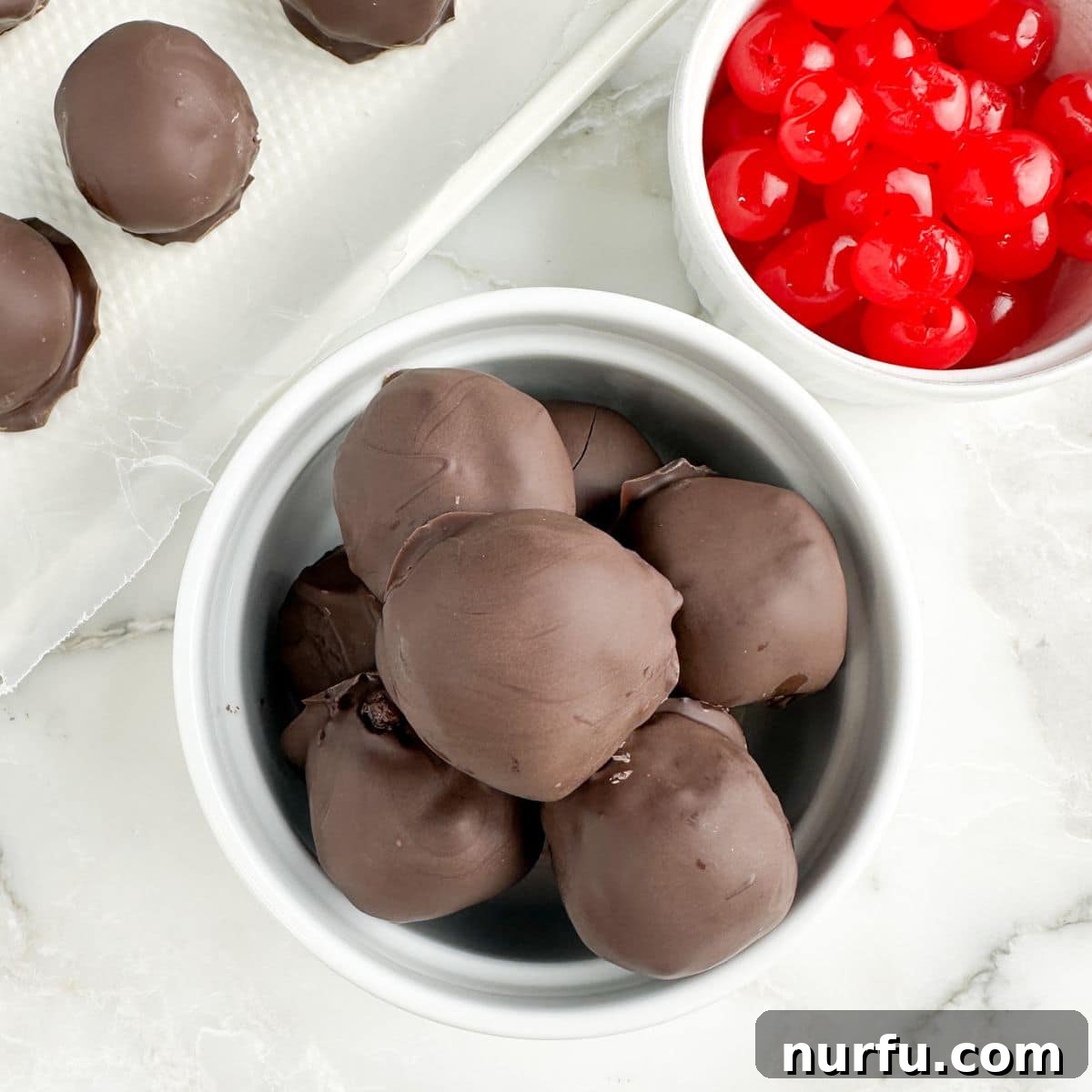 Irresistible Chocolate Cherry Brownie Bites 11 A finished bowl of chocolate-covered cherry brownie bites, glistening with their smooth chocolate coating, ready to be enjoyed.