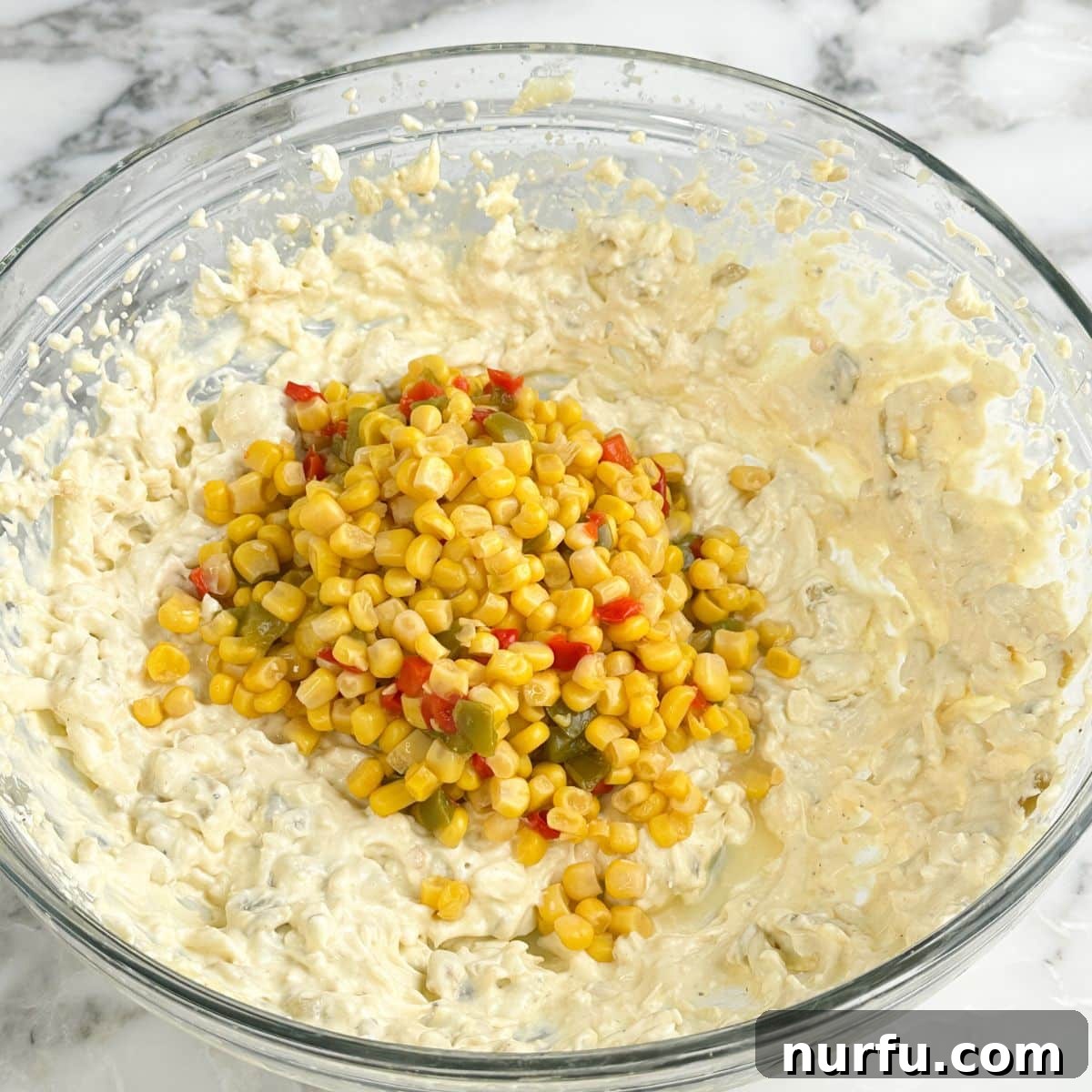 Hawkeye Hootenanny Bites 5 Bowl of the cream cheese mixture, with fiesta corn being added to it, ready for combining.