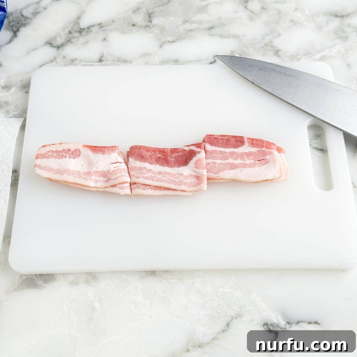 Uncooked bacon strips neatly cut into three equal pieces, ready for wrapping.