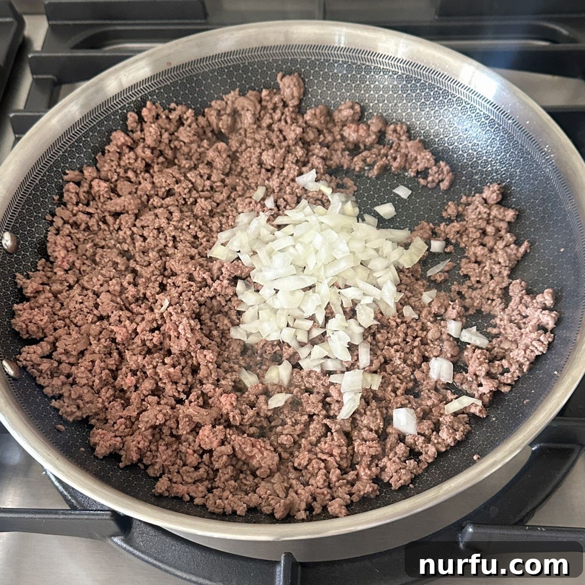 Fiesta Tortellini 4 A large skillet containing cooked ground beef mixed with translucent diced onions.