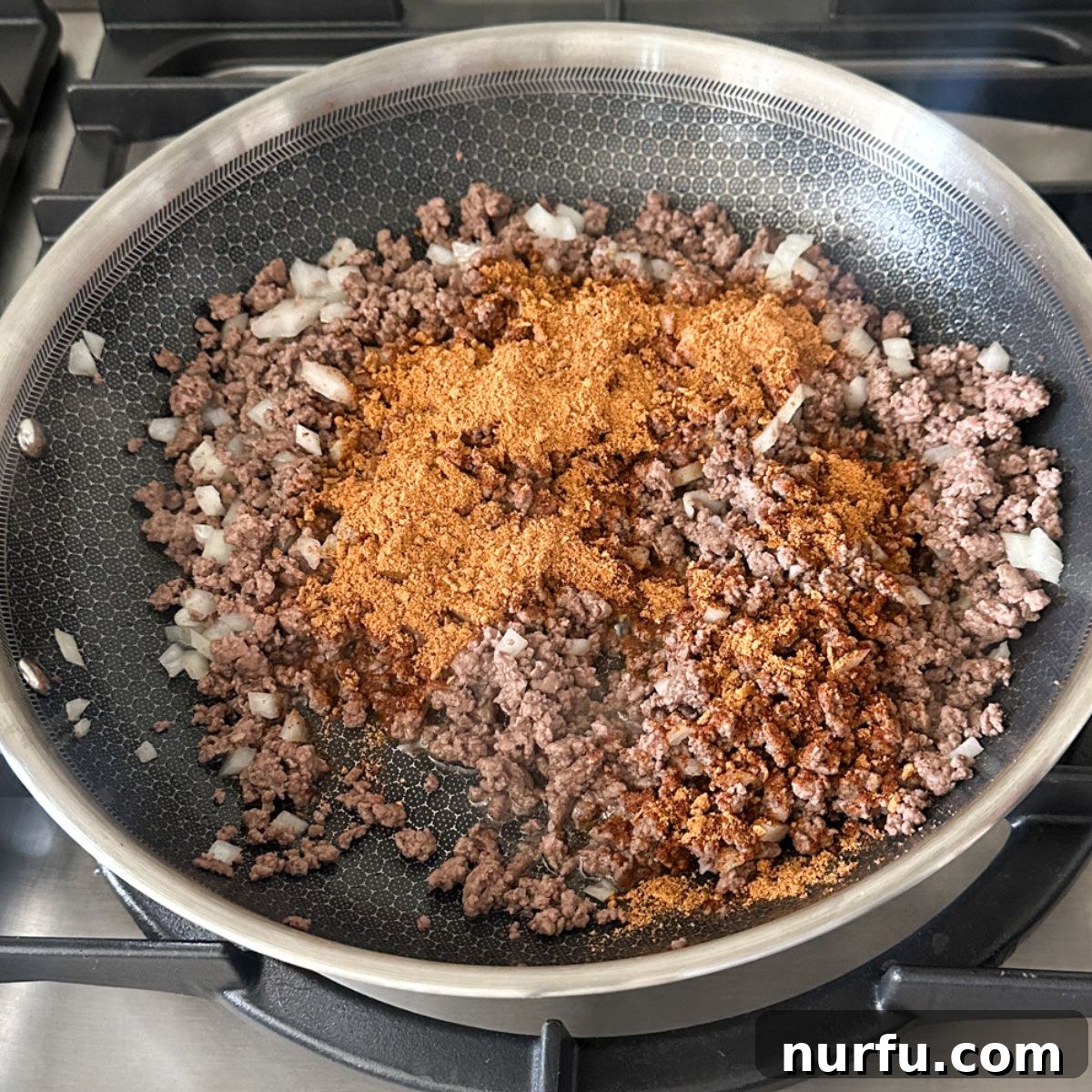 Fiesta Tortellini 5 Ground beef and diced onions in a skillet, now mixed with taco seasoning, ready for the next liquid ingredients.