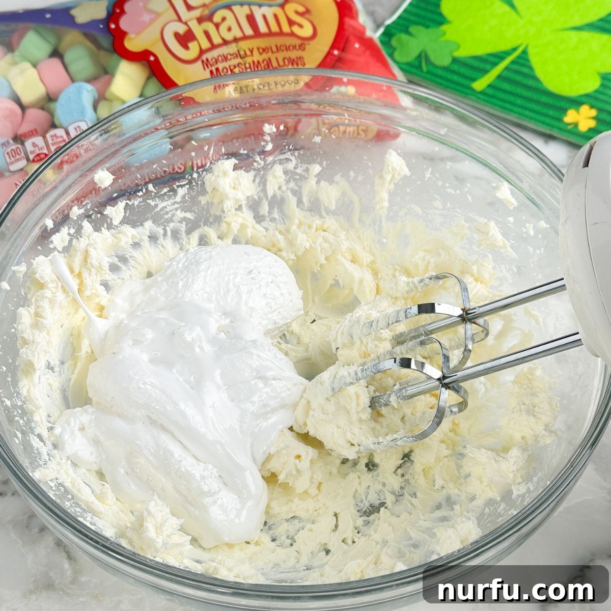 Pot of Gold Dessert Dip 4 Bowl with beaten cream cheese and marshmallow creme, ready for the next steps in making dessert dip.