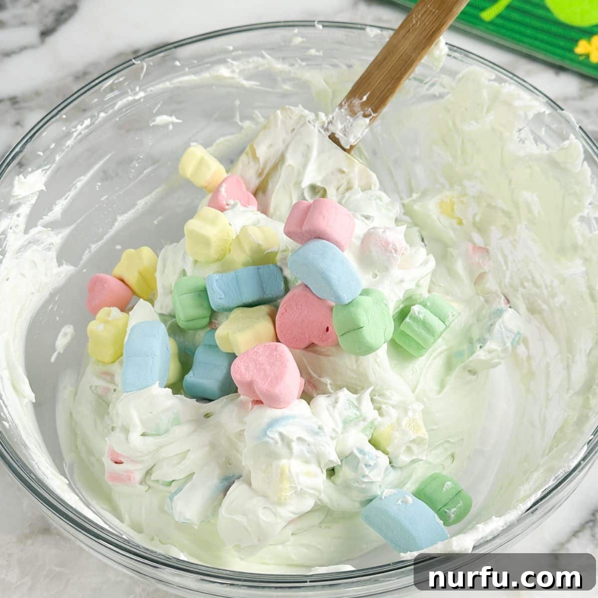 Pot of Gold Dessert Dip 6 Bowl of green dip with colorful marshmallows, showcasing the final mixed dessert.