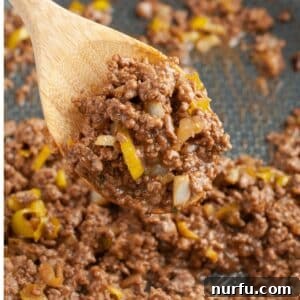 Wooden spoon with mississippi sloppy joe meat.