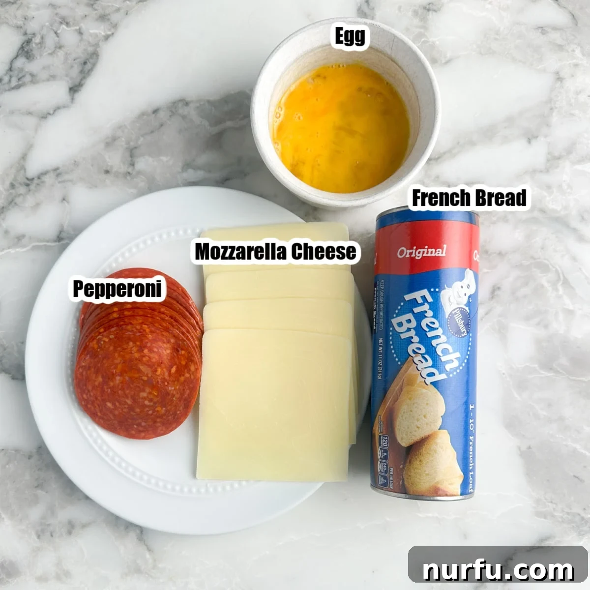 Cheesy Pepperoni Rolls 3 The four core ingredients for pepperoni rolls laid out: a can of French bread dough, sliced mozzarella cheese, a pack of pepperoni, and a single egg.