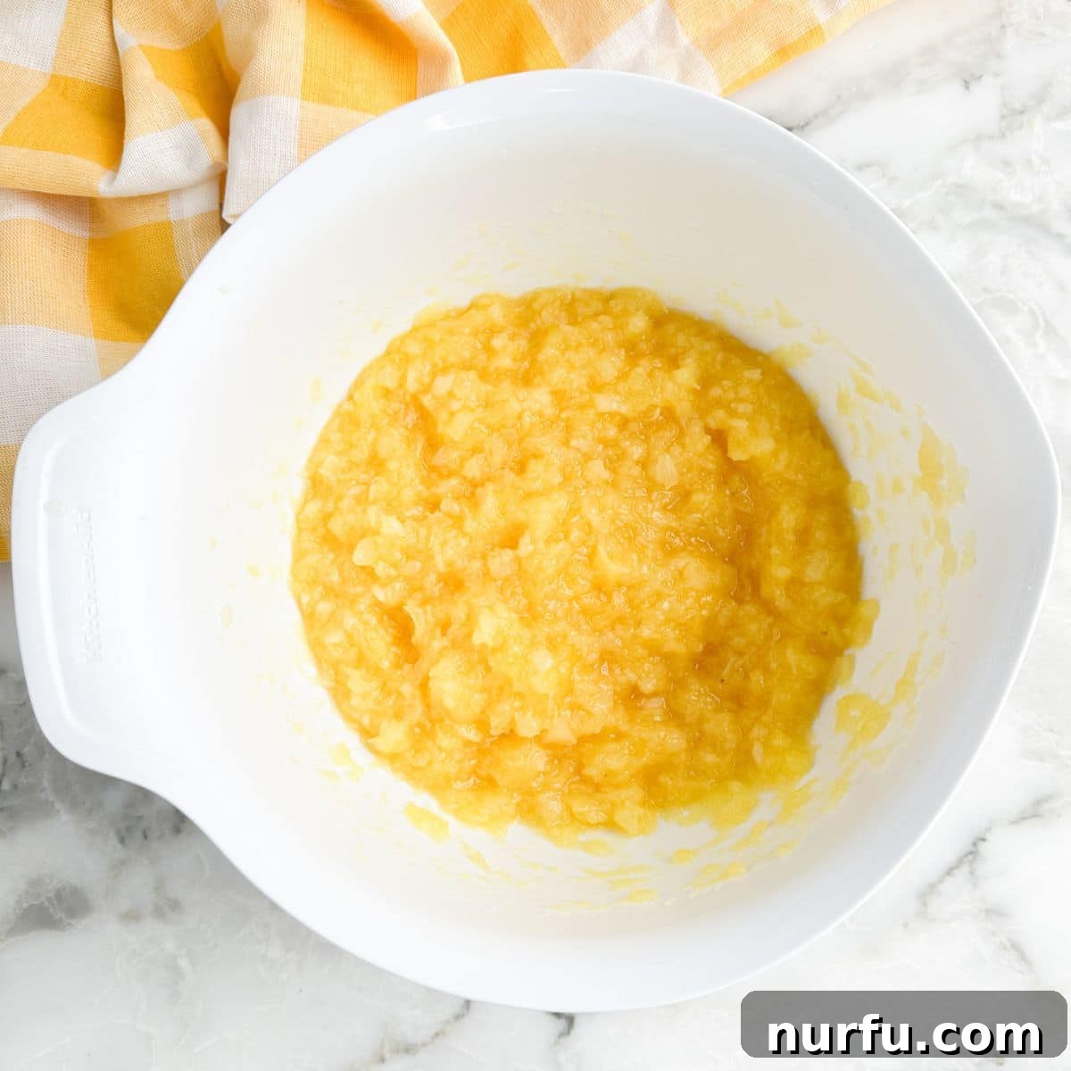 A bowl filled with crushed pineapple, ready for the next step in making Lemon Fluff.