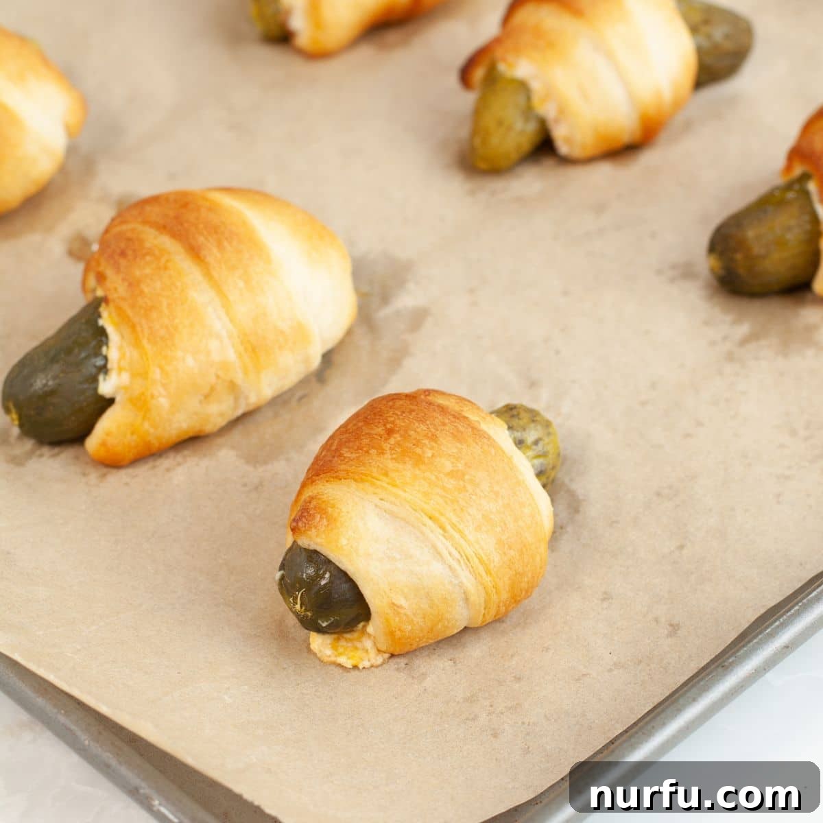 Tangy Pickle Bites 8 A baking pan filled with freshly baked, golden-brown pickles in a blanket.