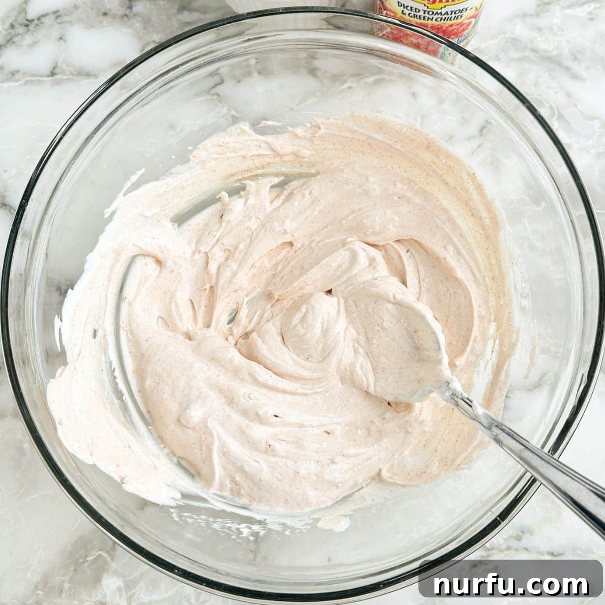 Zesty Fiesta Ranch Dip 5 A close-up of sour cream and fiesta ranch seasoning thoroughly mixed into a smooth, creamy base.