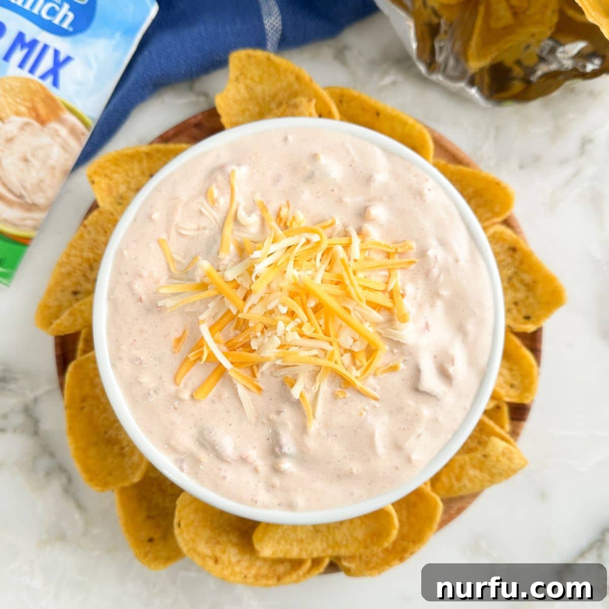 Zesty Fiesta Ranch Dip 8 A beautifully presented bowl of Fiesta Ranch Dip, surrounded by a variety of corn chips, ready for dipping.