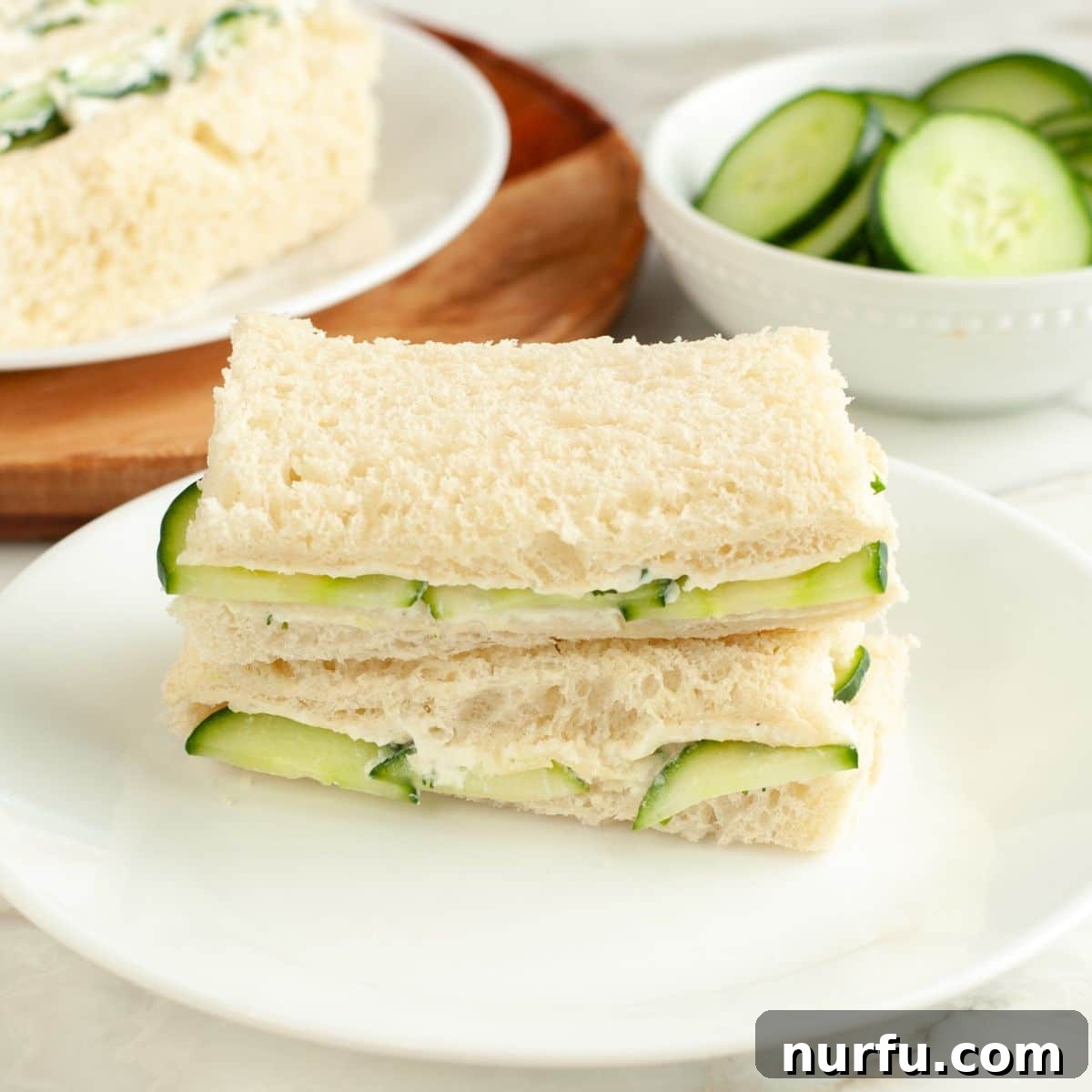 Elegant Cucumber Tea Bites 2 Plate of classic cucumber sandwiches, garnished with fresh dill.