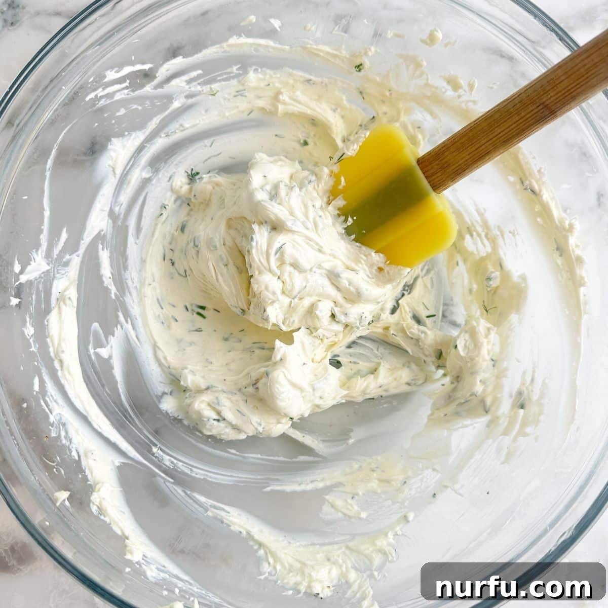 Elegant Cucumber Tea Bites 5 Bowl of whipped cream cheese spread with fresh herbs.