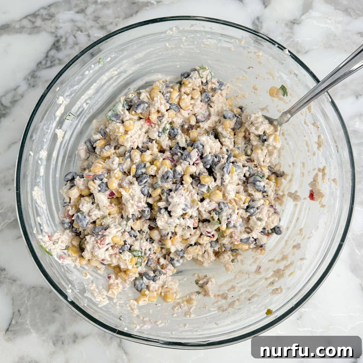 Southwest Grilled Chicken Salad with Avocado & Lime Dressing 7 Bowl of southwest chicken salad with a spoon.