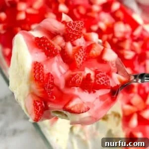 Strawberry Pudding Dessert Recipe: Creamy Berry Delight 7 Spoon with pudding topped with diced strawberries.