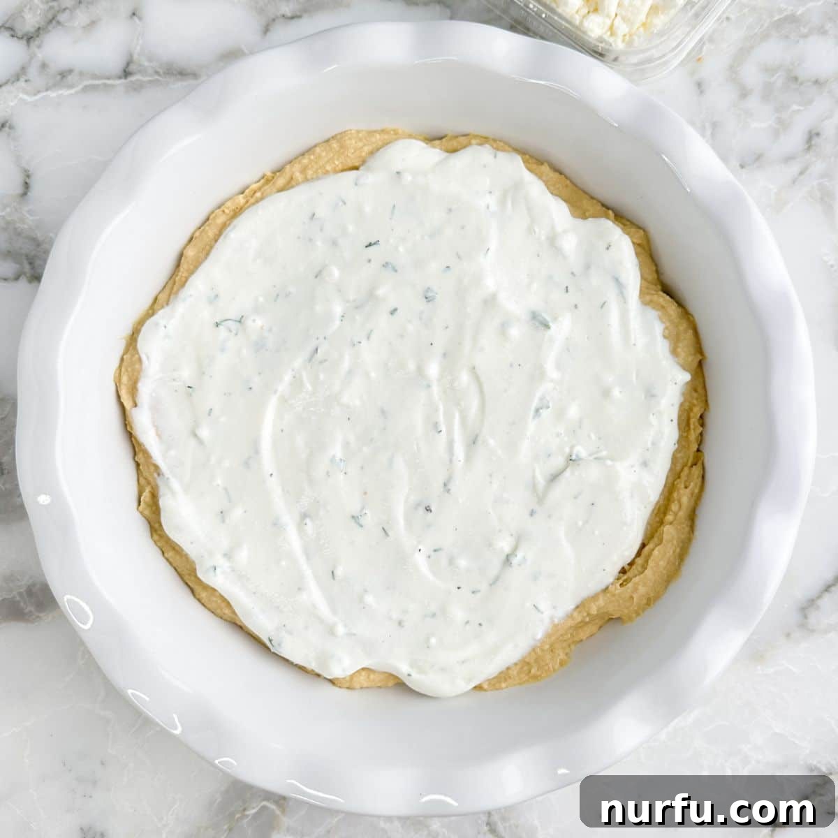 Mediterranean Greek Layer Dip Recipe – Flavorful Party Appetizer 5 Pie dish with hummus and Greek yogurt.