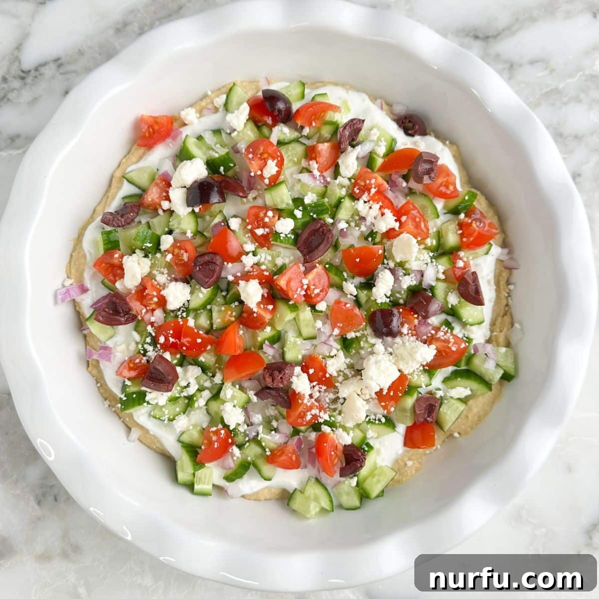 Mediterranean Greek Layer Dip Recipe – Flavorful Party Appetizer 6 Pie dish with Greek layer dip.