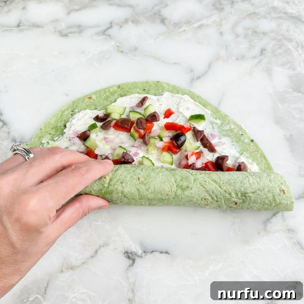 Greek Pinwheel Appetizers: Spinach, Feta & Olive Rolls 6 Tortilla pinwheel being rolled up.