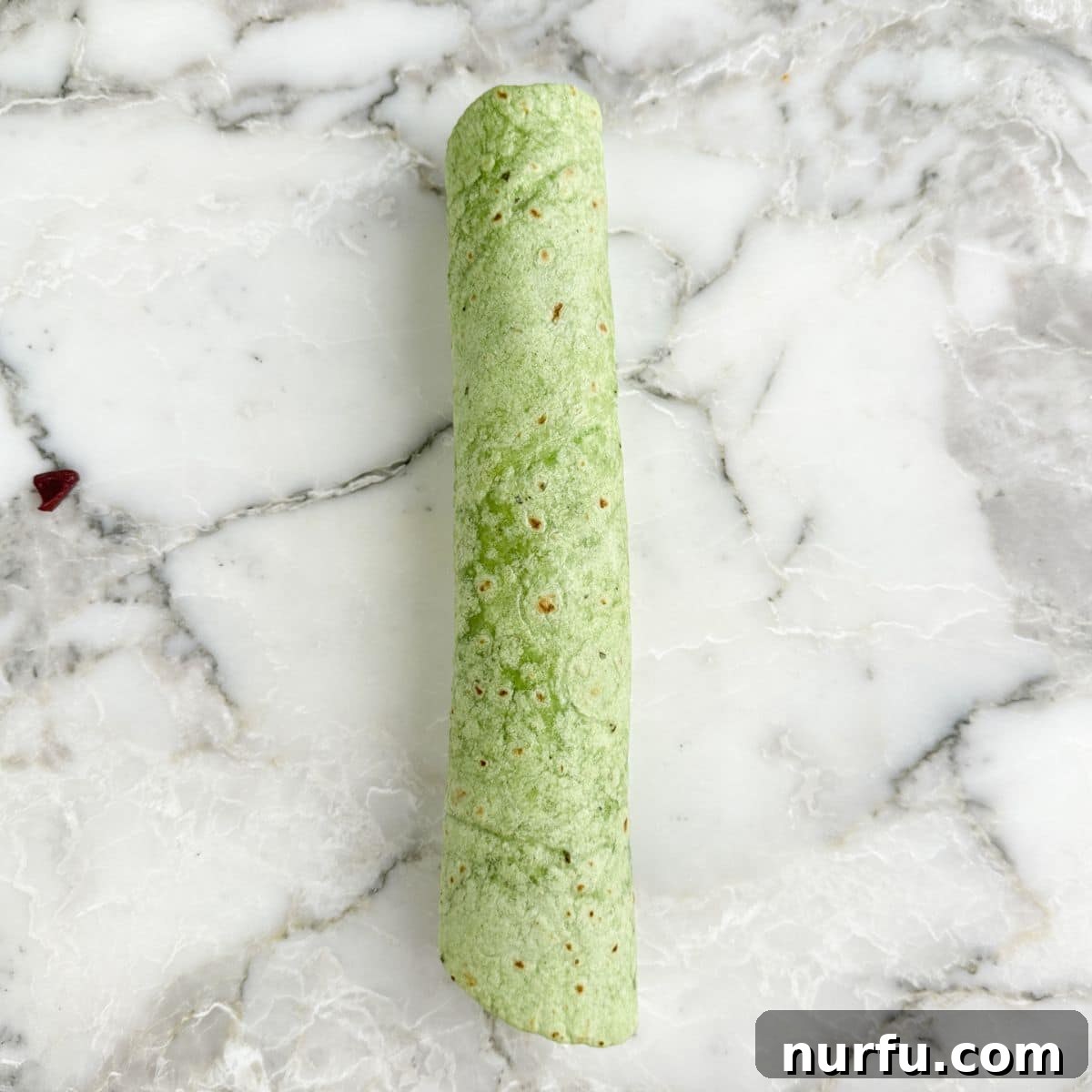 Greek Pinwheel Appetizers: Spinach, Feta & Olive Rolls 7 Green tortilla rolled up.