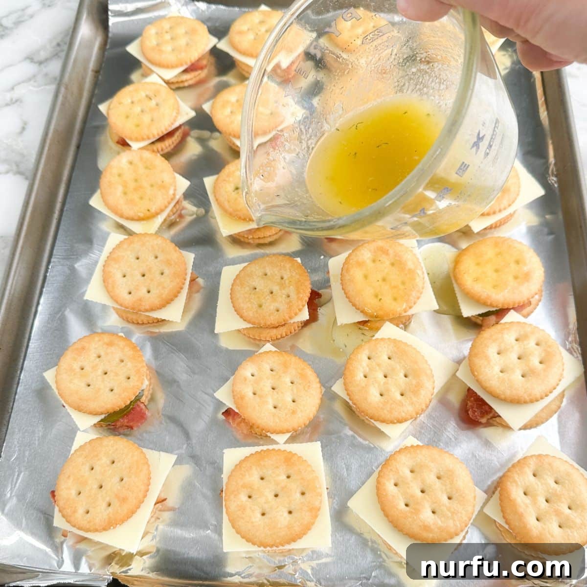 Ritz Crackers with Bacon and Pickle Spread: Crispy Party Snack 7 Melted butter being poured over crackers.