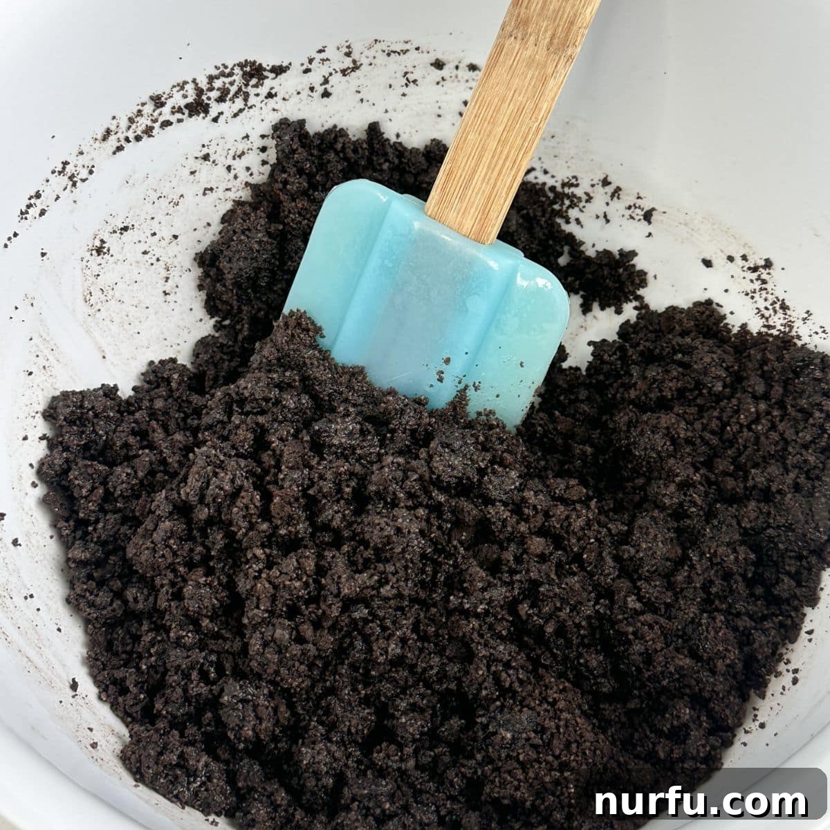 Bowl with Oreo crumbs and a spatula.