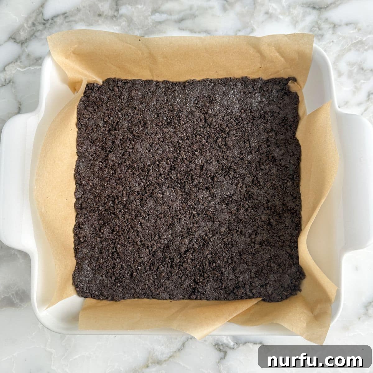 Oreo crust in a baking pan.