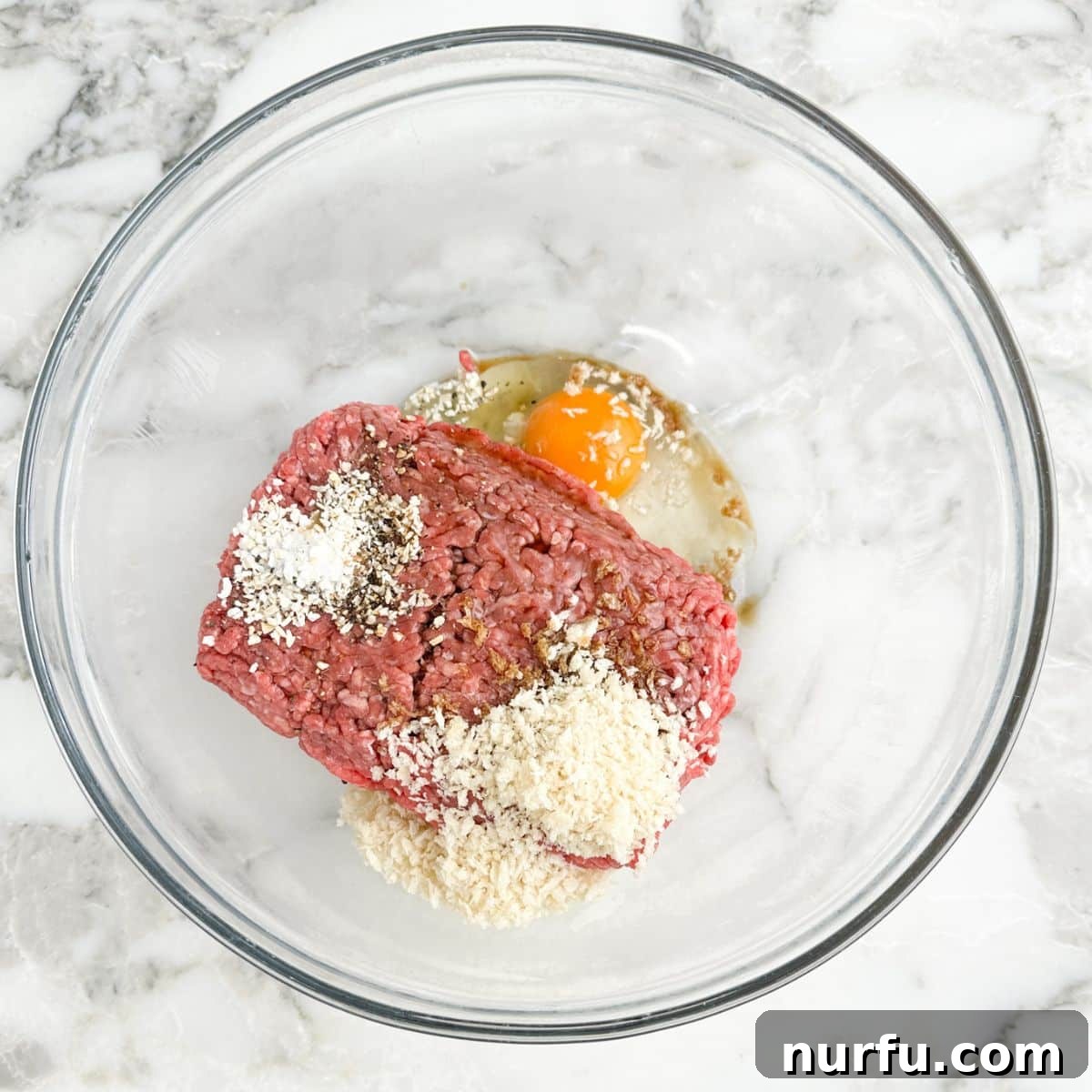 Mini Meatloaf Muffins Recipe with Cheesy Center 4 Bowl with ground beef, Panko bread crumbs, egg, and seasonings.